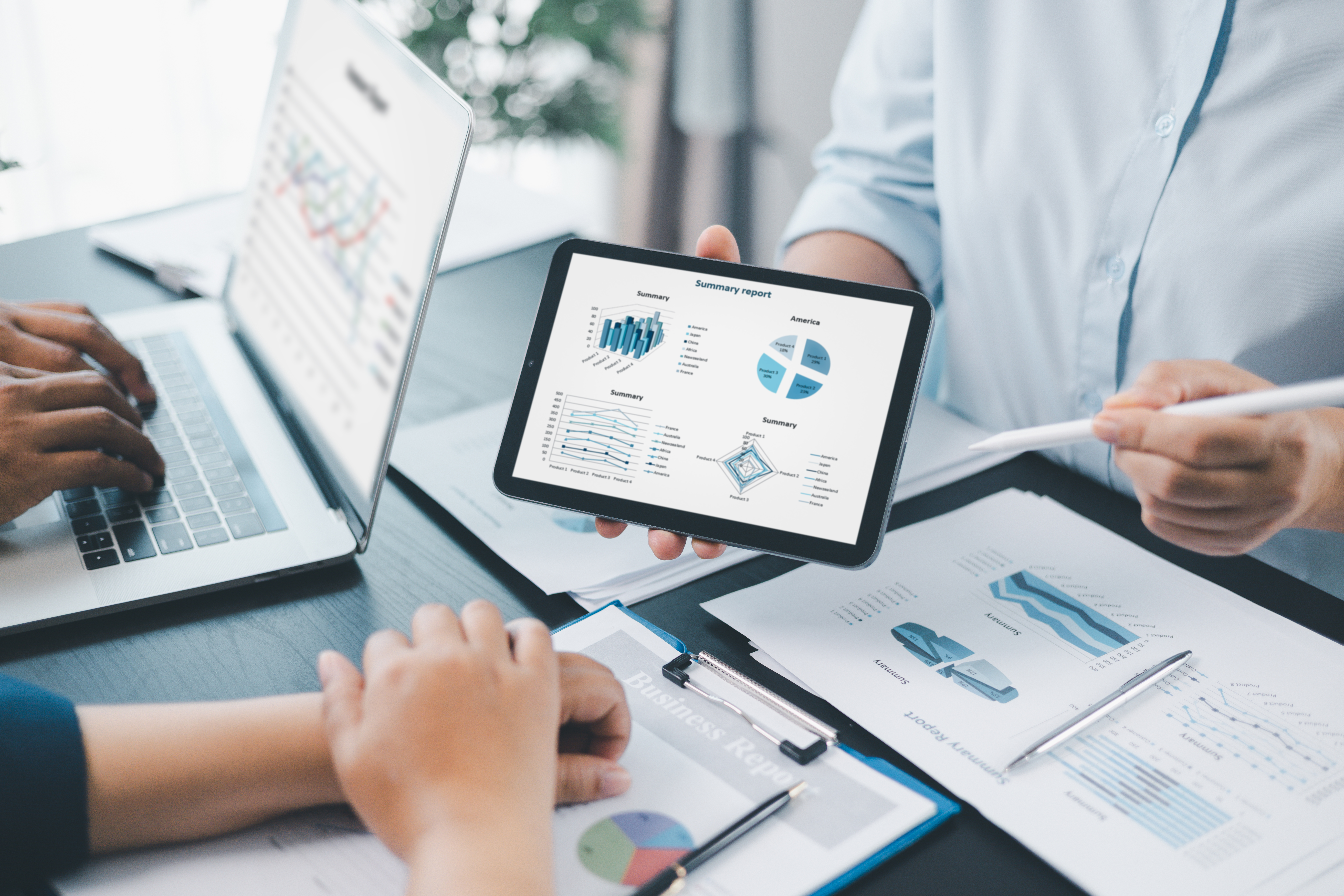 Business data analysis concept with colleagues reviewing financial report on tablet, pointing at chart with growth graph, teamwork discussing statistics, planning strategy and corporate success.